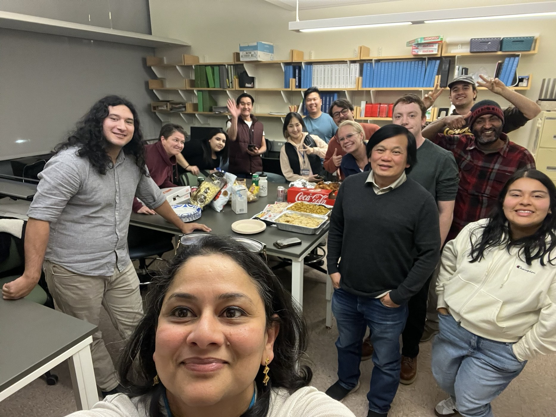 Graduate students and faculty gathered informally in a lab setting